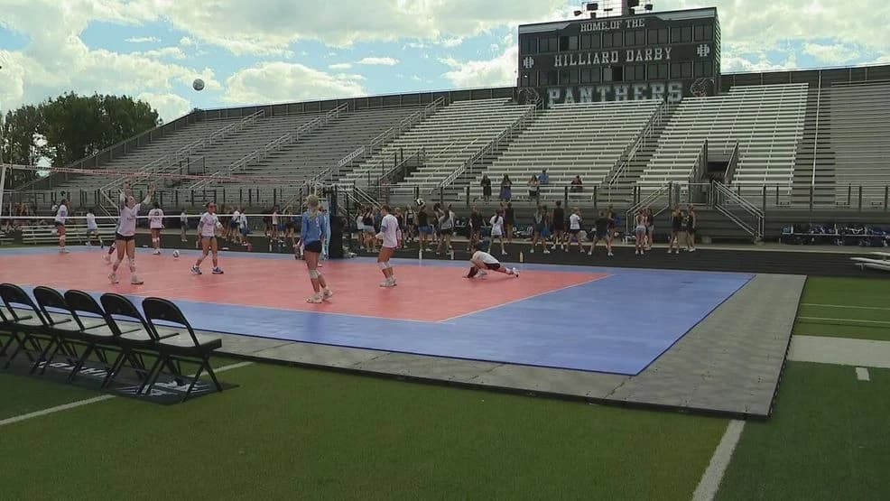 Outdoor portable volleyball court and net system set up on a field